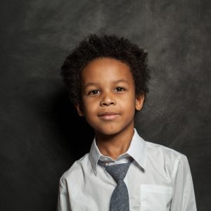 Happy black kid school boy. Smart child on blackboard background